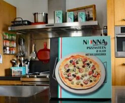 Nonna Pizzasteen Ø30,5 Met RVS Serveerrek - Stenen Pizzaplaat / Ovenplaat (11mm Dik) Voor Oven En Barbecue (BBQ) - Maximaal 600 Graden Celcius -Barbecue Benodigdheden Winkel 1200x985 2